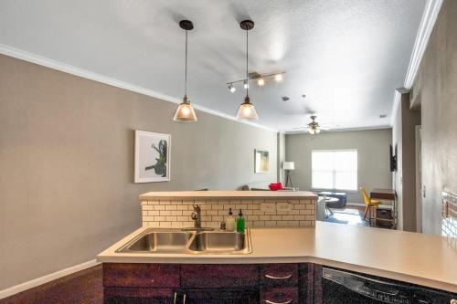 a kitchen with a sink and a living room at Charming 1BD in Trendy West End Neighborhood in Dallas