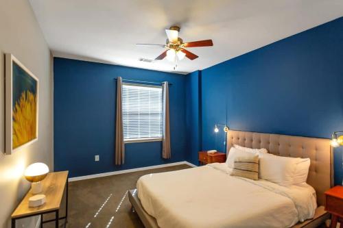 een blauwe slaapkamer met een bed en een plafondventilator bij Trendy Place to Stay in Downtown next to Convention Center in Dallas