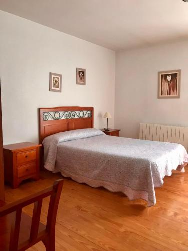 1 dormitorio con 1 cama grande y suelo de madera en Elsoto, en Quintana del Pidio