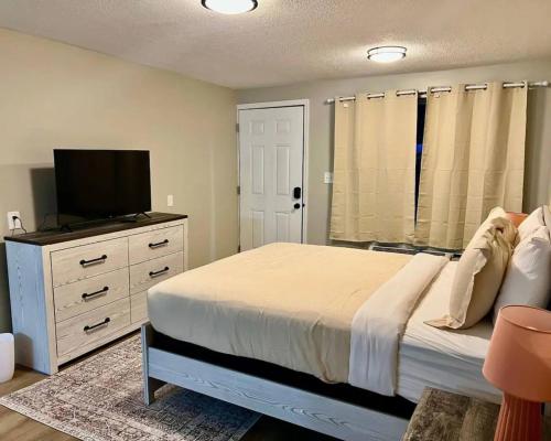 a bedroom with a bed and a flat screen tv at Wildflower Room At The Trailblazer Unit 15 in Townsend