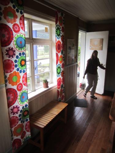a woman walking into a room with a window at Hostal Compass del Sur in Puerto Varas