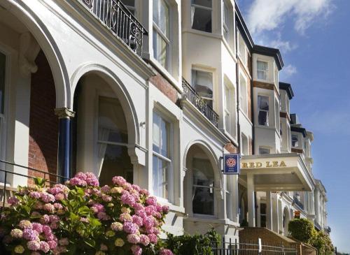 a white building with flowers in front of it at Red Lea Apartments with Pool & Spa Access in Scarborough