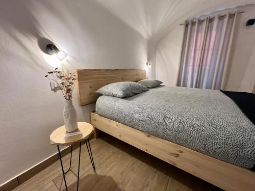 a bedroom with a bed and a vase of flowers on a table at AIR σϝ HOME Aραɾƚɱҽɳƚ in Novi Ligure