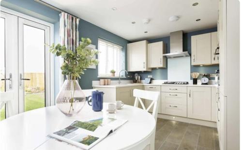 a kitchen with white cabinets and a vase with flowers at Stunning stylish 3bed house in Reading city centre in Reading