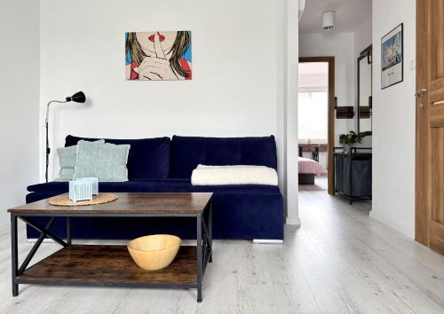 a living room with a blue couch and a table at Apartamenty Marea Rentals Grunwaldzka Ustka in Ustka