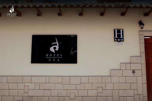ein Schild an der Wand eines Gebäudes in der Unterkunft Hotel Baños del Inca in Los Baños del Inca