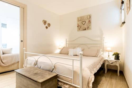 a white bedroom with a white bed and a table at Casa vacanze La Scala d'Oro in Orvieto