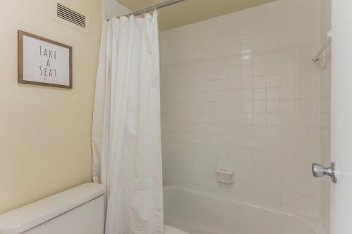 een badkamer met een douche met een wit douchegordijn bij Affordable Memphis Apartment Near Top Restaurants in Memphis