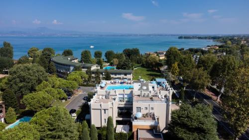an aerial view of a large white building and the water at Hotel Alfieri in Sirmione