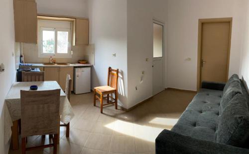 eine Küche und ein Wohnzimmer mit einem Sofa und einem Tisch in der Unterkunft Apartment Santino 6 in Ksamil