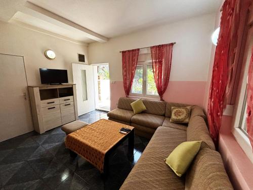 uma sala de estar com um sofá e uma mesa em Stone Villa em Bečići