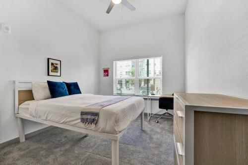 1 dormitorio con cama con almohadas azules y escritorio en Dockside on Lake Hartwell near Death Valley en Clemson