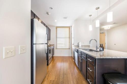 a kitchen with a stainless steel refrigerator and wooden floors at The Lofts at Cherry DT w Amenities in Macon