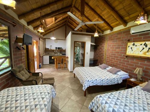 a bedroom with two beds and a living room at Las Cabañas in Olón