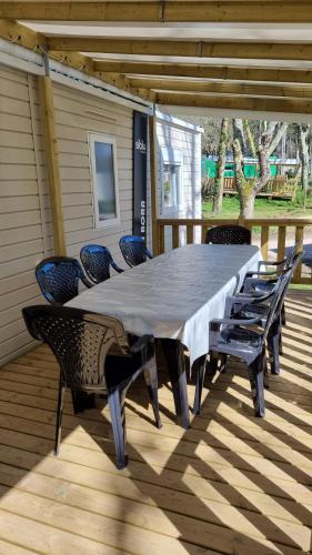 a table and chairs on a deck with a table and chairs at Mobil home in Piriac-sur-Mer