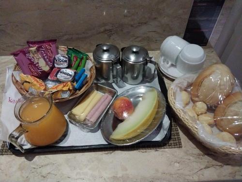 een dienblad met eten, een drankje en wat eten bij Motel Karinho 3 in Santo André