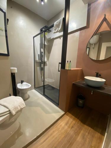 La salle de bains est pourvue d'une douche en verre et d'un lavabo. dans l'établissement Esposizione Roof, à Rome