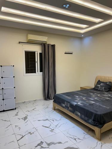 a bedroom with a bed in a room with marble floors at Maison Blanche in Nouakchott