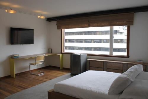 a bedroom with a bed and a desk and a television at Amazing Vintage Apartment in Centro Internacional RColon 601 in Bogotá