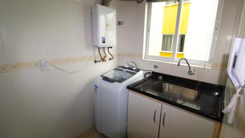 baño pequeño con fregadero y nevera en 1006 - Apartamento com vista para o mar, en Bombinhas