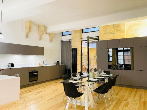 une cuisine et une salle à manger avec une table et des chaises dans l'établissement Loft Bordelais, à Bordeaux