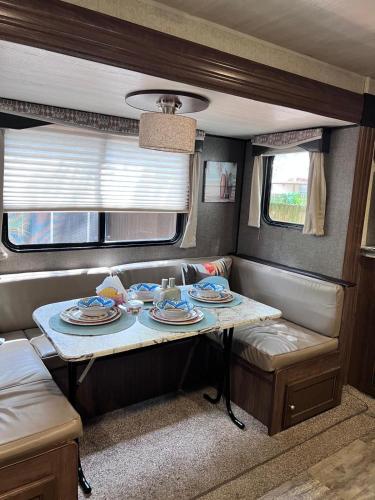 a table in an rv with plates and dishes on it at Garden Paradise RV Camper near Clearwater Beaches in Largo