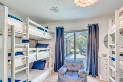 a bedroom with white bunk beds and a window at Charming Riverfront Home with Kayaks! in Crystal River