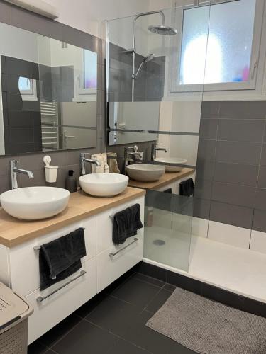 uma casa de banho com 2 lavatórios e um espelho grande em Apartment in Calm Neighborhood em Eaubonne
