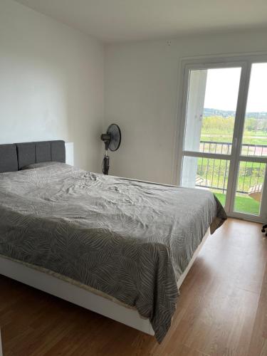sypialnia z łóżkiem i dużym oknem w obiekcie Apartment in Calm Neighborhood w mieście Eaubonne