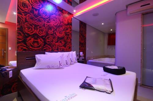 a bedroom with a large bed and a bath tub at Karinho Hotel 4 in Santo André