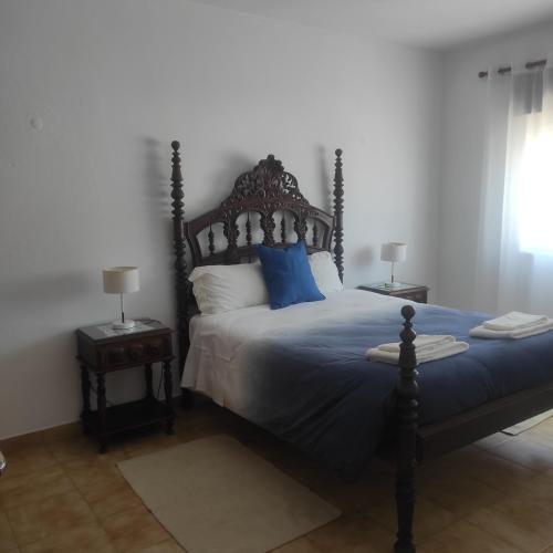 a bedroom with a bed with blue sheets and blue pillows at Casa Furtado in Burgau