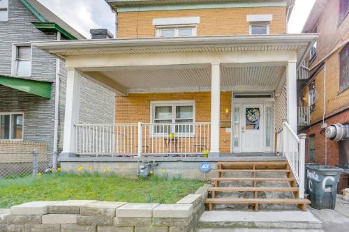 a house with a porch and a white door at Cozy East Pittsburgh Home - 7 Mi to Frick Park! in East Pittsburgh