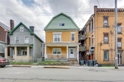 a house with a green roof on a city street at Cozy East Pittsburgh Home - 7 Mi to Frick Park! in East Pittsburgh