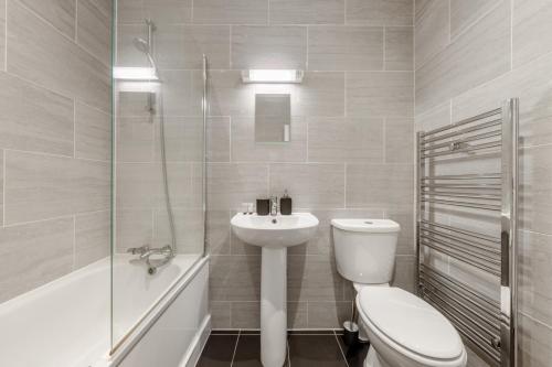 埃奇韋爾的住宿－London Edgware Station，白色的浴室设有卫生间和水槽。