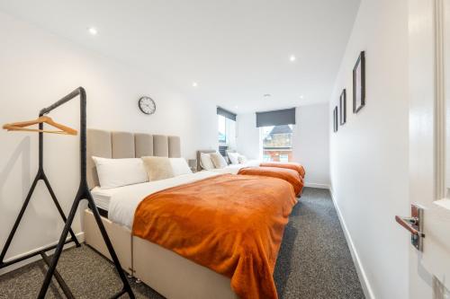 1 dormitorio con 3 camas con mantas de naranja en London Edgware Station, en Edgware