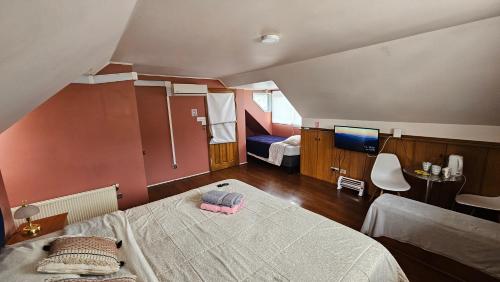 1 dormitorio con 1 cama y TV. en Hostal Casona del Mar en Viña del Mar