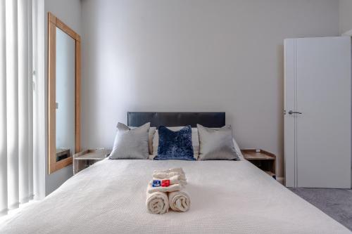 a bedroom with a white bed with towels on it at Chic 1BR with Garden View in Central Bristol in Bristol