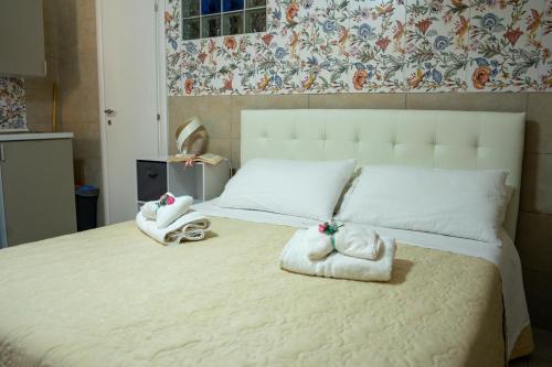 een slaapkamer met een groot wit bed en handdoeken bij Mary Maira in Siracusa