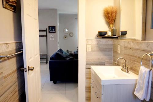 a bathroom with a sink and a living room at Lil Havana-Brickell-South Beach in Miami