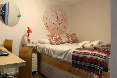 1 dormitorio con cama, escritorio y espejo en Encántate, Cabina Estudio., en Ñilque