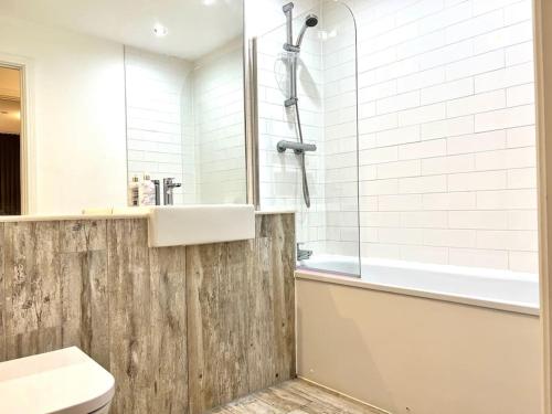 een badkamer met een wastafel, een toilet en een bad bij Lovely 2 bedroom Apartment in Central Manchester in Manchester