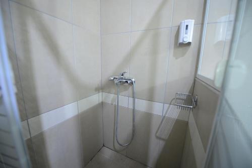 baño con ducha y puerta de cristal en Central Hotel, en Paralia Katerinis