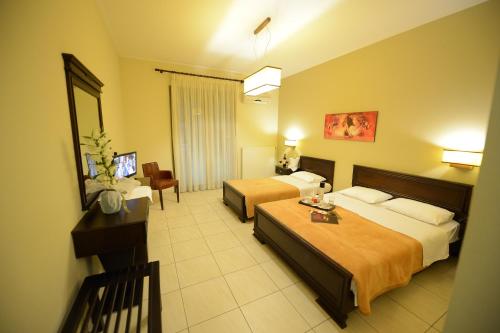 Habitación de hotel con 2 camas y mesa en Central Hotel en Paralia Katerinis