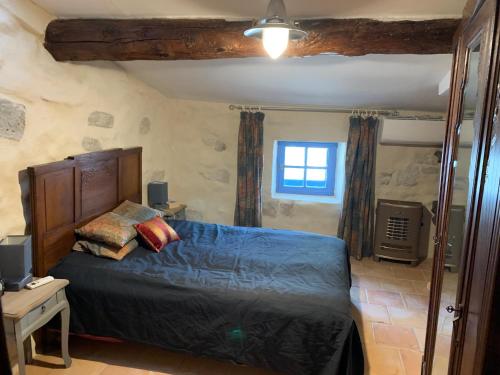 une chambre avec un grand lit et une fenêtre dans l'établissement Le Passadou, à Peyriac-de-Mer