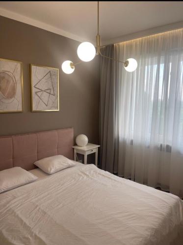 a bedroom with a bed with two lamps and a window at AirPort Apartment Chopina in Warsaw