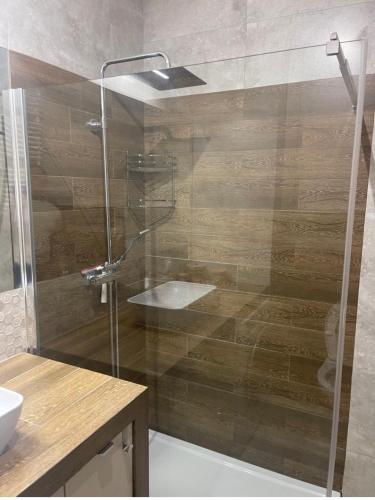 a shower with a glass door in a bathroom at AirPort Apartment Chopina in Warsaw