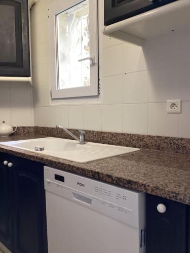 un comptoir de cuisine avec un évier et une fenêtre dans l'établissement La Casa d'Isabelle, Charme Corse à Patrimonio, à Patrimonio