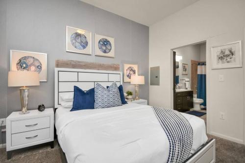 een slaapkamer met een groot wit bed met blauwe kussens bij Haus of Blues* Walk to NRG* TX Med Center* Downtown in Houston