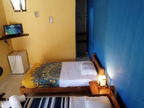 a bedroom with a bed and a blue wall at Punta Pacífico Bungalows Máncora in Máncora