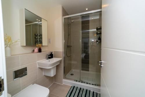 een badkamer met een douche, een toilet en een wastafel bij Stunning 4 bed house near stadium and green park in Reading